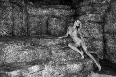 Güzel, seksi sarışın kadın model seksi bikini şelale arka plan üzerinde yalan