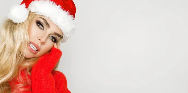 Schöne sexy blonde weibliche Modell mit einem Weihnachtsmann Hut gekleidet. sinnliches Mädchen zu Weihnachten. — Stockfoto