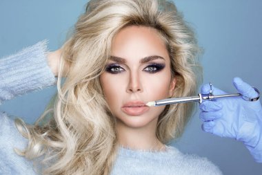 Mükemmel yüz ve güzel saçları ile güzel, seksi sarışın kadın portresi. Estetik tıp prosedürü sırasında güzellik modeli.