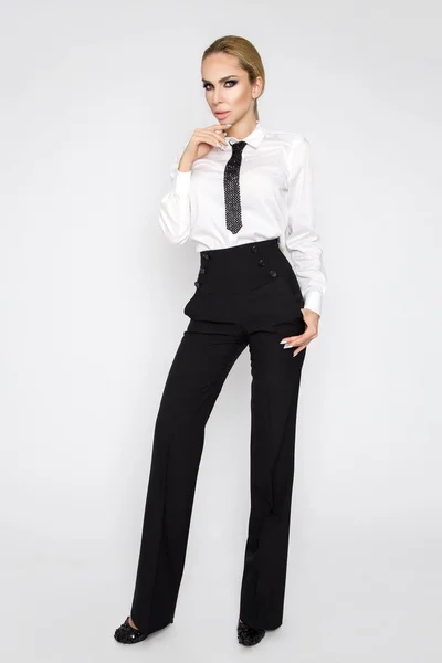 Hermosa, elegante, sexy modelo rubia vestida con camisas blancas y corbata y pantalones negros. Sensual mujer de negocios con gafas —  Fotos de Stock