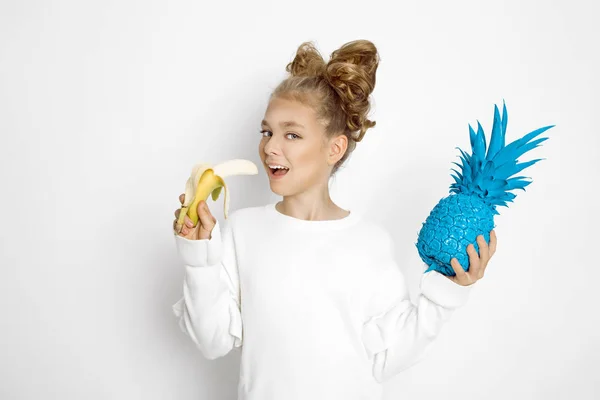 Bonito, bela menina loira com arco de cabelo. Beleza e menina alegre, ela segurando frutas coloridas . — Fotografia de Stock