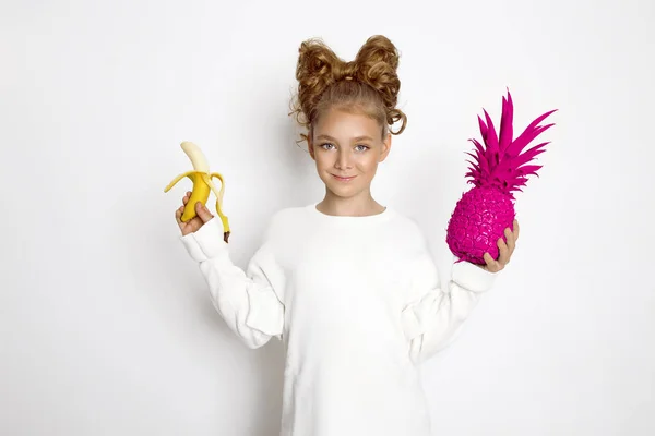 Linda, hermosa chica rubia con lazo de pelo. Belleza y chica alegre, ella sosteniendo frutas coloridas . — Foto de Stock