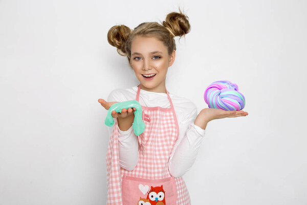 Симпатичная смешная девушка со слизью на кухне. Девушка готовит и печет свои кексы, делает торт и слизь
.