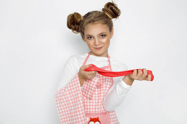 Симпатичная смешная девушка со слизью на кухне. Девушка готовит и печет свои кексы, делает торт и слизь
.