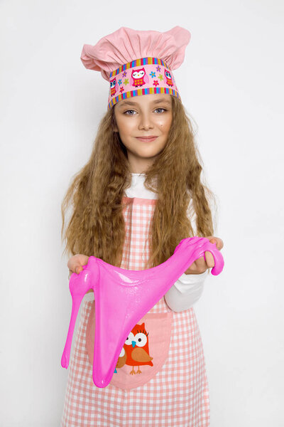 Симпатичная смешная девушка со слизью на кухне. Девушка готовит и печет свои кексы, делает торт и слизь
.