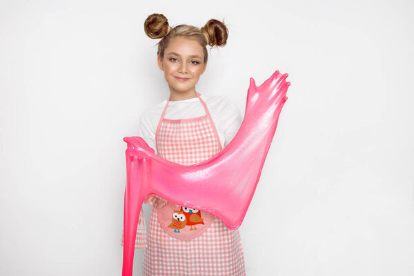 Симпатичная смешная девушка со слизью на кухне. Девушка готовит и печет свои кексы, делает торт и слизь
.