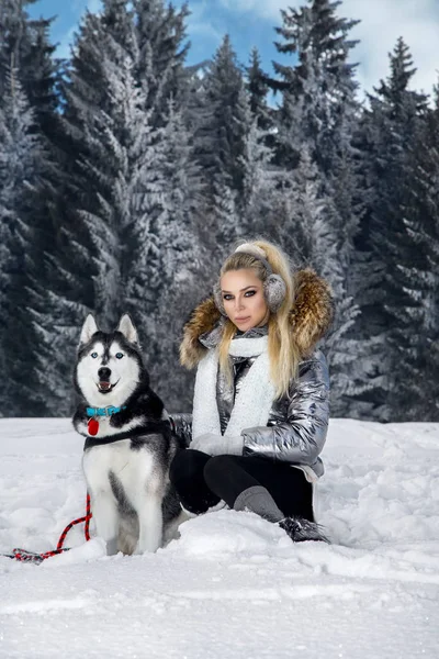 Piękna Blondynka Kobieta Stojąc Śniegu Trzyma Psy Husky Tle Jest — Zdjęcie stockowe