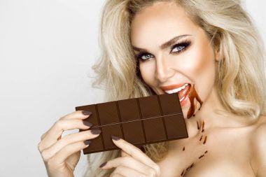 Güzel, seksi sarışın, sensually yeme çikolata.