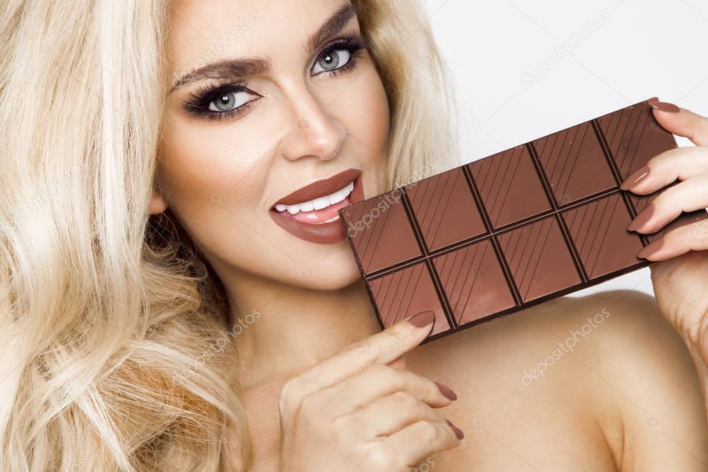 Beautiful, sexy blonde, sensually eating chocolate.