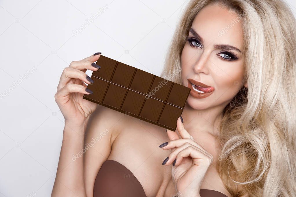 Beautiful, sexy blonde, sensually eating chocolate.