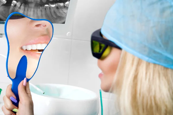 歯科用の椅子の上に座って美しい白い歯と若くてきれいな女性 歯科医は彼女の歯を治療します — ストック写真