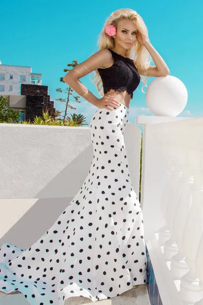 プールサイドで立っているエレガントな水玉ドレスで美しく セクシーな女性 — ストック写真