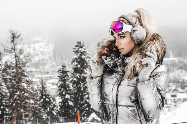 Beautiful young woman in winter, ski clothing on a background of — 스톡 사진