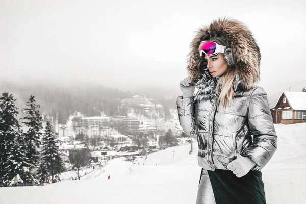 Beautiful young woman in winter, ski clothing on a background of — 스톡 사진