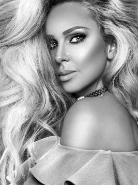 Uzun ve parlak dalgalı saçlı sarışın kız. Kıvırcık saçlı ve doğal güzel yüzlü güzel bir manken. Siyah beyaz fotoğraf