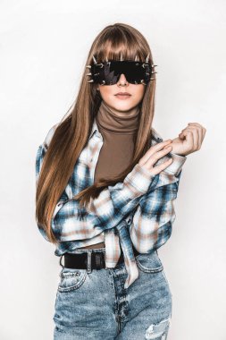 Pürüzsüz saçlı güzel bir genç kızın moda portresi. Bluzlu ve kot pantolonlu kız. Kıyafet ve saç stili. Güneş gözlüklü bir genç. Modaya uygun. Cazibeli stil düşkünü genç model