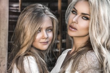 Neşeli anne ve kızın portresi. Neşeli bir anne ve kız, açık havada güneşli bir tatilin tadını çıkarıyor. Aile sevgisi ve yaşam tarzı.