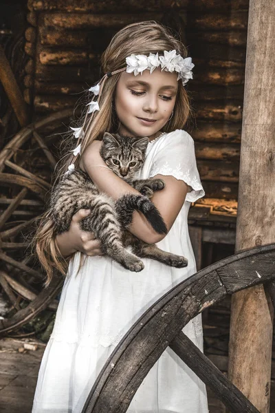 優しさと猫を愛し 幸せと笑顔の小さなかわいい子供の肖像画 子猫と公園でリラックスしている少女 白い聖餐式のドレスの子供は猫とキスしている 春のファッション — ストック写真