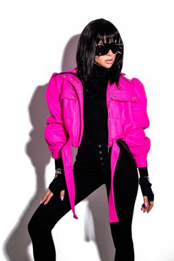 Modaya uygun. Beyaz arka planda izole edilmiş renkli giysili göz kamaştırıcı güzel kız modeli. Stüdyoda şık kıyafetler içinde poz veren şık esmer kadın. Sıradan stil.