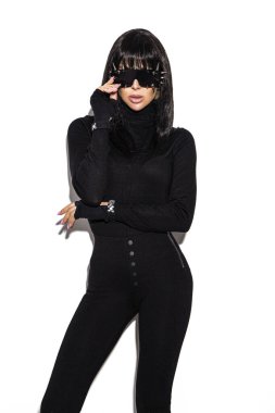 Modaya uygun. Beyaz arka planda izole edilmiş siyah elbiseli alımlı güzel bir model. Stüdyoda poz veren güzel, şık esmer kadın. Siyah beyaz konsept.