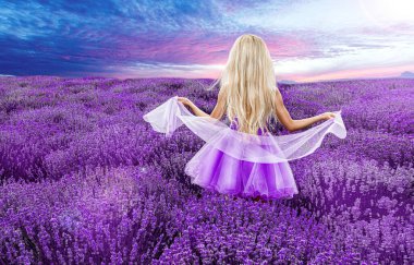 İlkbaharda ya da gündoğumunda lavanta tarlasında yürüyen güzel bir model. Lavanta tarlasında sarı saçlı kız - Görüntü