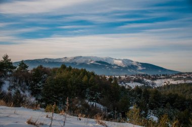 Kış mevsiminde gün batımında karlı dağların manzarası