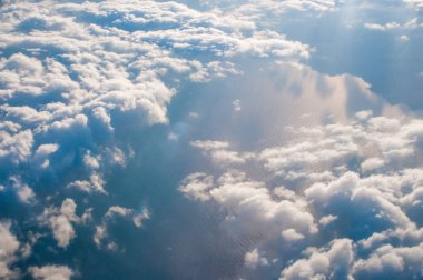 Kabarık bulutlar üzerindeki uçak penceresinden arkaplan olarak görünüm 