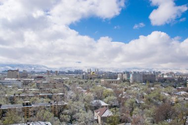 Bulutlu gökyüzü arkaplanındaki şehir manzarasının hava görüntüsü, Almaty