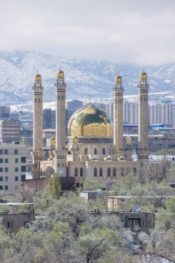 Almaty, Kazakistan - Nisan 2020: Yeşil şehirde, dağların önünde altın kubbeli modern cami. 