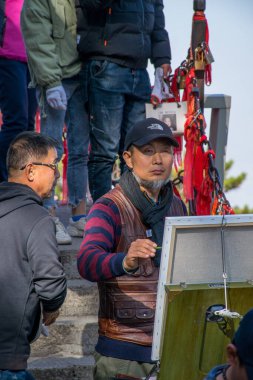 Xi 'an, Çin - Ekim 2019: Sanatçı Huashan Dağı' nın tepesini resmediyor. Shaanxi 'deki en popüler tatil beldelerinin zirvesi..