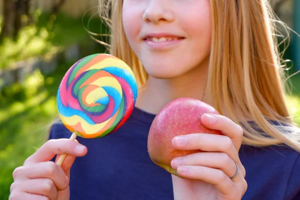 Adolescente loira caucasiana menina em top azul escolhendo entre junk food maçã alegre e saudável. Conceito saudável de desintoxicação alimentar limpa . — Fotografia de Stock