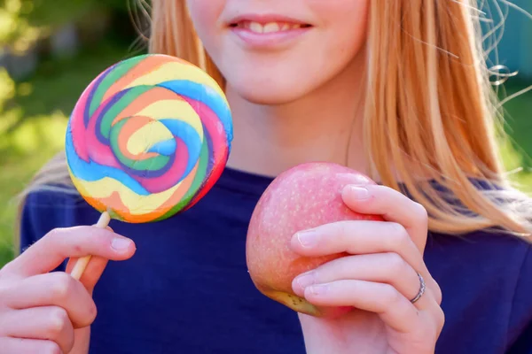 Adolescente loira caucasiana menina em top azul escolhendo entre junk food maçã alegre e saudável. Conceito saudável de desintoxicação alimentar limpa . — Fotografia de Stock