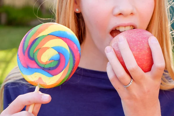 Adolescente loira caucasiana menina em top azul escolhendo entre junk food maçã alegre e saudável. Conceito saudável de desintoxicação alimentar limpa . — Fotografia de Stock