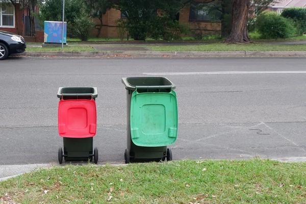 Αυστραλοί κάδοι σκουπιδιών με πολύχρωμα καπάκια για την ανακύκλωση οικιακών απορριμμάτων και πράσινα απορρίμματα κήπων τοποθετημένα στο πεζοδρόμιο για τη συλλογή απορριμμάτων του συμβουλίου — Φωτογραφία Αρχείου