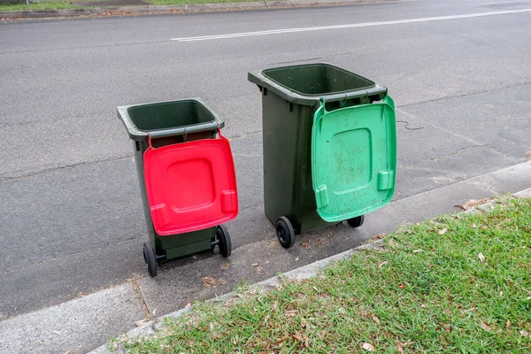 Australijskie kosze na śmieci z kolorowymi pokrywkami do recyklingu odpadów z gospodarstw domowych i zielonych odpadów ogrodowych ustawione na krawężniku ulicy do zbierania odpadów komunalnych — Zdjęcie stockowe