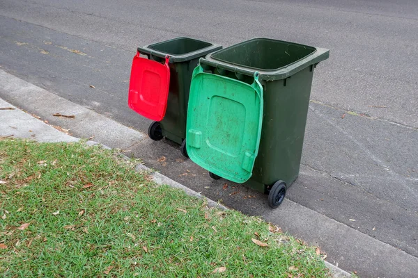 쓰레기 재활용을 위해 화려 한 뚜껑 이 있는 오스트 레일리 아산 쓰레기통 과 의회 쓰레기 수집을 위해 길가에 줄지어 늘어선 푸른 정원 폐기물 — 스톡 사진