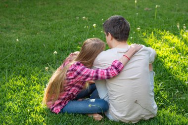 Baba genç kızına kulaklık takarak sarılıyor. Ebeveynler ve gençler arası ilişki kavramı