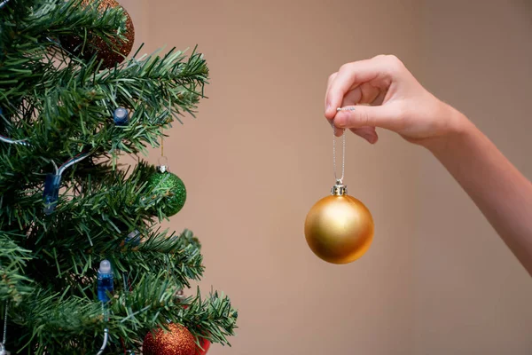 Χέρι κρατώντας μπιχλιμπίδι μπάλα Χριστουγέννων για να διακοσμήσετε το χριστουγεννιάτικο δέντρο — Φωτογραφία Αρχείου