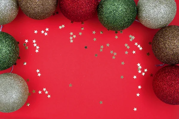 Boules de Noël boules sur un fond rouge avec des étoiles dorées. Espace vide pour la saisie de texte — Photo