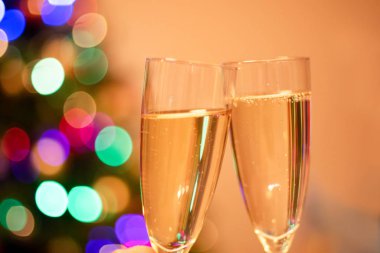 Bulanık Noel ağacı ve köpüklü şampanyalı iki bardak.