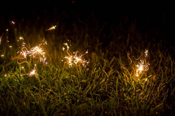 Geceleri çimlerde parıldıyor. Kutlama konsepti. Mutlu yıllar. — Stok fotoğraf