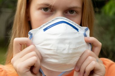 Avustralya çalı yangını: P2 N95 koruma maskesi takan sarışın kız çalıların dumanından nefes alan Pm2.5 parçacıklarının miktarını azaltmak için. Maskeye odaklan