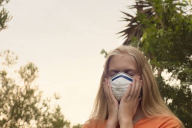 Avustralya çalı yangını: P2 N95 koruma maskesi takan sarışın kız çalıların dumanından nefes alan Pm2.5 parçacıklarının miktarını azaltmak için solunum maskesi.