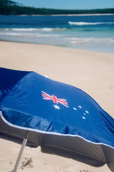 Journée Asutralia et arrière-plan du concept d'immigration : parapluie patriotique australien avec drapeau australien sur la belle plage de sable fin . — Photo