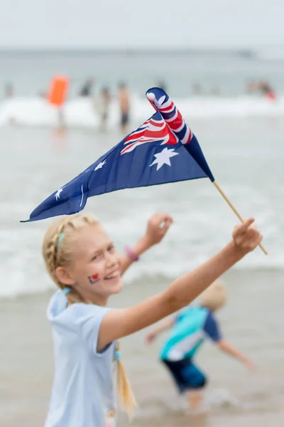 Linda rubia caucásica con bandera australiana y tatuaje temporal en su cara en el Día de Australia cerca de la playa del océano . —  Fotos de Stock