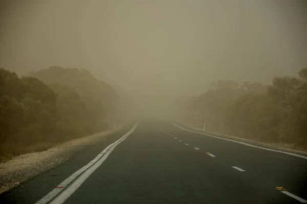 Burza piaskowa na drodze niedaleko Mildury w Australii. Cząstki pyłu w powietrzu powodują niską widoczność — Zdjęcie stockowe