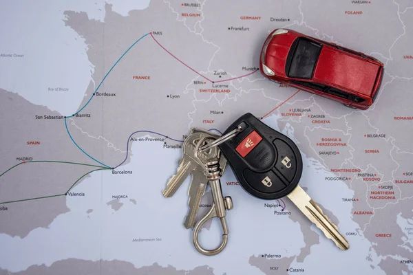 Araba kiralama ve seyahat konsepti. Biraz bulanık Avrupa haritasında kırmızı bir araba ve araba anahtarı — Stok fotoğraf