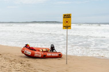 Cronulla, Avustralya 2020-02-15 plajı Sydney sahilinde kapalı tabela ve sörf kurtarma botu. Uyarıya rağmen insanlar hala yüzüyor ve sörf yapıyor.