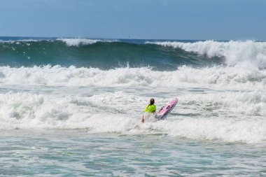 Sydney, Avustralya 2020-02-15 Wanda Beach, NSW, Avustralya 'da dalgalarda yüzen Kracka uçlu bir kız..