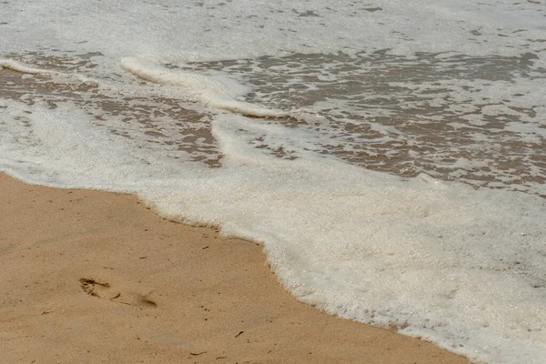 Dalgalarda Köpük Kumlu Sahilde Yalnız Ayak Izleri — Stok fotoğraf